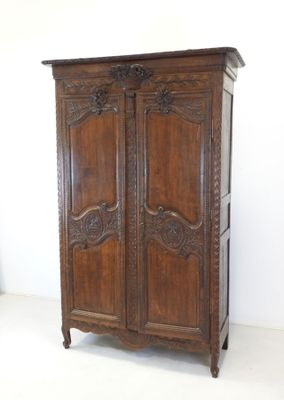 an image of a wooden armoire with carvings on the doors