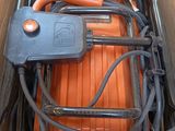 an orange suitcase in a cardboard box with a hose