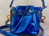 a blue bucket bag with a gold chain strap
