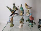 a glass table with a bunch of figurines of birds on it