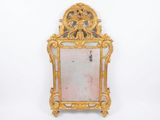 un miroir avec un cadre doré sur un mur blanc