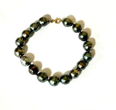 the bracelet is made of black pearls and a gold plated clasp