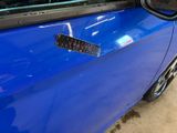 a close up of a blue car with a sticker on it