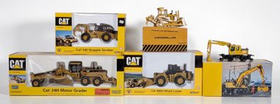 four boxes of toy construction vehicles sitting on a white surface