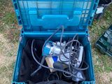 a blue box with a drill in it sitting on the grass