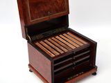a wooden box with a cigar in it on a white surface