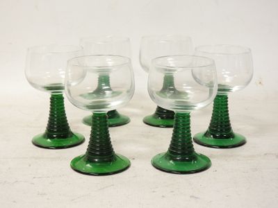 four green wine glasses sitting on top of each other on a table