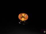 a yellow sapphire stone on a black surface