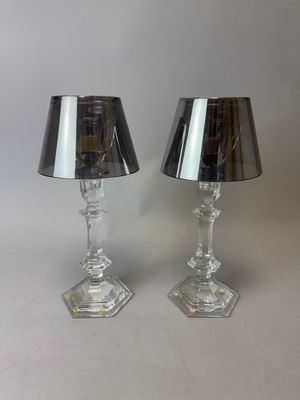 une paire de lampes en verre transparent avec des abat-jours noirs sur fond blanc