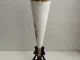 a white vase on a stand on a white floor