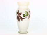 un vase blanc orné de feuilles vertes sur fond blanc