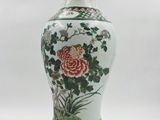 a white vase with a floral design on it