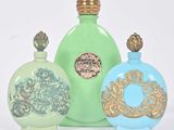 trois flacons de parfum posés les uns à côté des autres sur une surface blanche