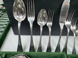 several forks and spoons are in a green box with a green lid