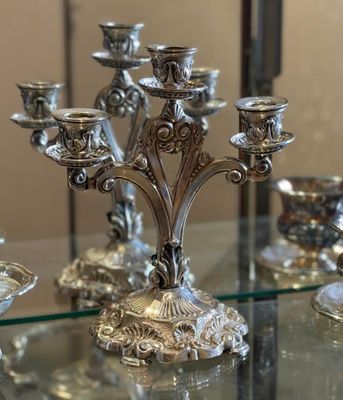 a silver candelab that is sitting on a glass table