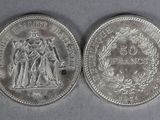 two silver coins, one of which is a woman and one of which is a man