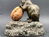 statue of a mouse eating a walnut on a rock