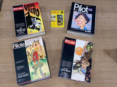 de nombreux livres posés sur une table, avec un ordinateur portable à l'arrière-plan