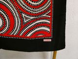 a red and black scarf hanging on a clothes rack
