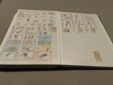 an open book with stamps on it sitting on a table