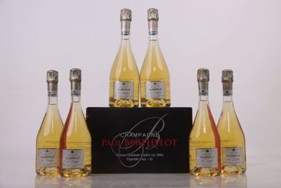 Quatre bouteilles de vin sont posées sur une table, à côté d'une boîte noire.