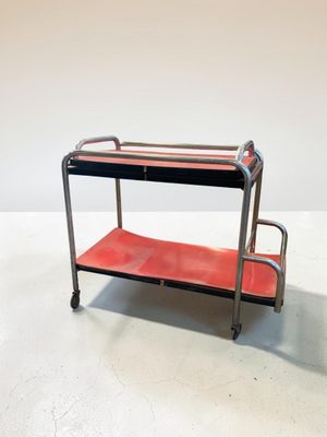 un chariot orange et noir muni de deux étagères sur le dessus