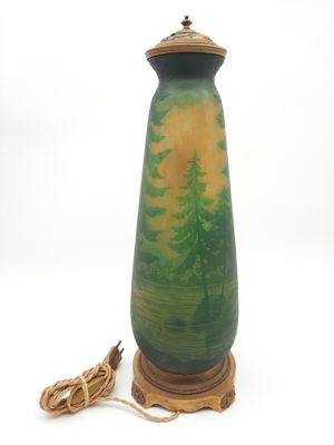 un vase vert et jaune sur lequel sont peints des arbres