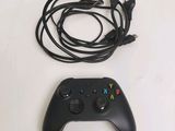 a black game controller and a charger on a table