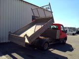a red truck with a ramp in front of a building