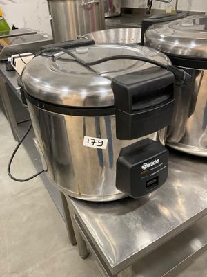two stainless steel pots sitting on a table in a kitchen