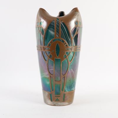 un vase avec un motif sur une surface blanche