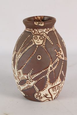 un vase brun et blanc posé sur une surface blanche