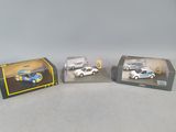 three toy cars are sitting in a display case on a table