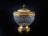 une image représentant un bol recouvert d'or et de cristal posé sur une surface noire