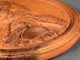 a bronze plaque of a woman and a horse on a table