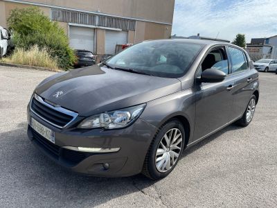 La voiture grise est garée sur le parking devant le bâtiment.