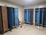 several blue lockers in a room with a chair in it
