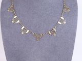 the necklace is made of silver metal and has a geometric design