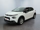Une Citroën blanche est garée dans une pièce blanche