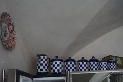 de nombreux vases bleus et blancs posés sur une étagère au-dessus d'un micro-ondes