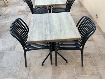 de nombreuses tables et chaises sur la terrasse à l'extérieur du bâtiment