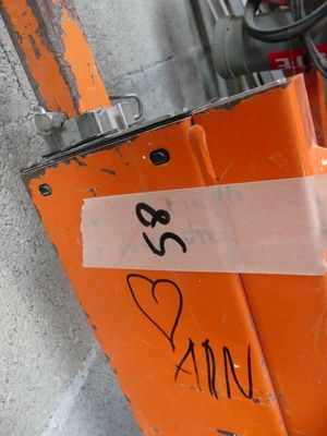 une enseigne fixée sur le mur d'un immeuble, sur laquelle est collé un autocollant
