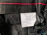 a label on a black jacket with a red stripe