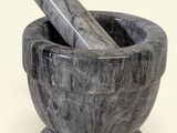 marble mortar and pestle with a wooden pestle in the middle