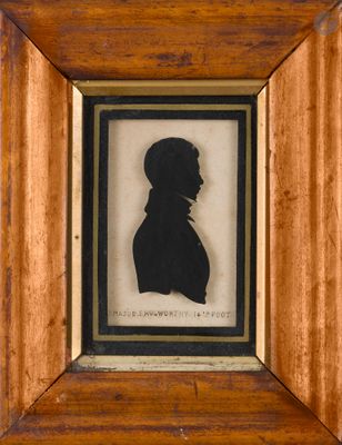 une vieille photo représentant la silhouette d'un homme, dans un cadre en bois