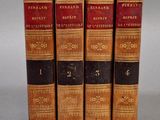 quatre vieux livres empilés les uns sur les autres sur une table