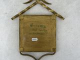 brass plate with a bird on top of it on a white surface