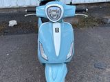 un scooter bleu garé devant un immeuble