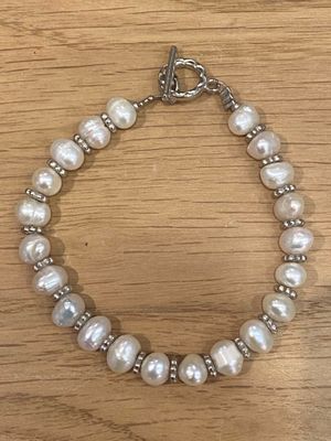 un gros plan d'un bracelet orné de perles posé sur une table en bois