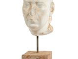 une image représentant une sculpture représentant une tête d'homme posée sur un bloc de bois